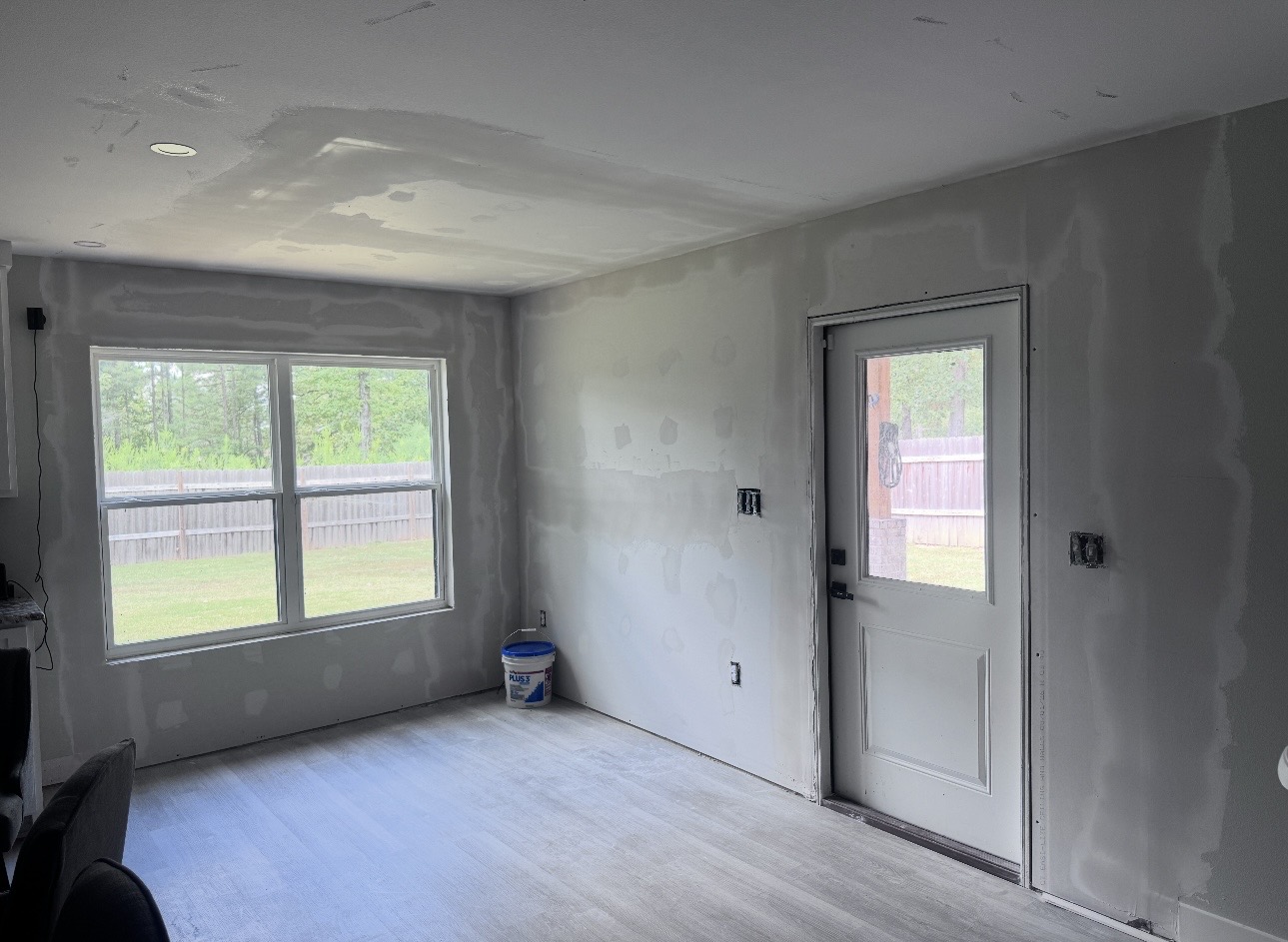 Interior room with newly repaired unfinished drywall on walls and ceiling